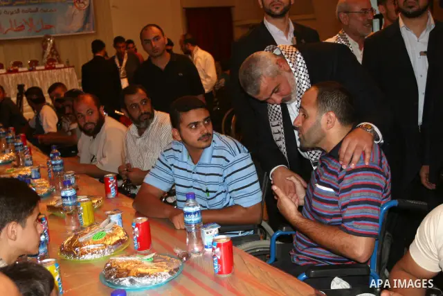 Palestinian Prime Minister in Gaza Strip, Ismail Haniyeh takes his breakfast during the Islamic holy month of Ramadan with Palestinians who were injured during the Israeli war on Gaza in 2008 at al-Helaw hotel in Gaza ci...