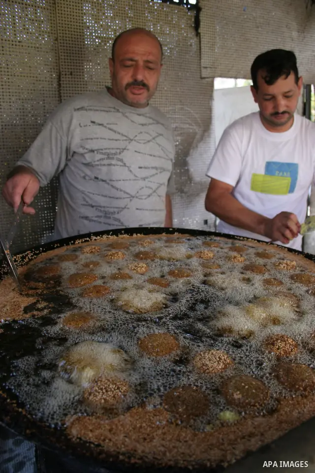 A Palestinian prepares deep fried falafel as he waits for customers several hours before Iftar, the breaking of the day long Ramadan fast in the old city of the West Bank town of Hebron, on August 26, 2010, as Muslims al...