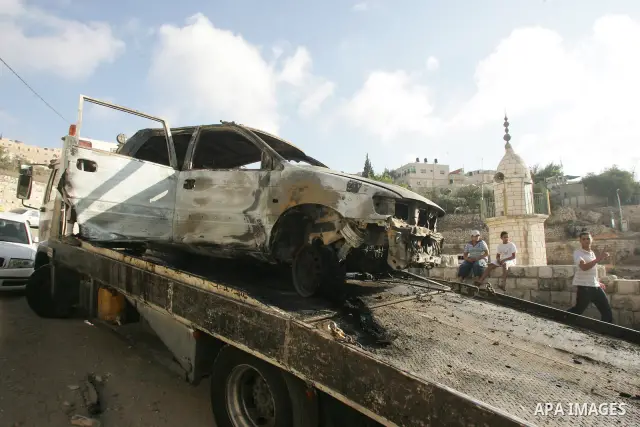Palestinians stand next to burned cars following clashes in the neighborhood of Silwan in east Jerusalem, Thursday Aug. 26, 2010. According to Palestinian witness riots broke out after masked Jewish men tried to enter a...