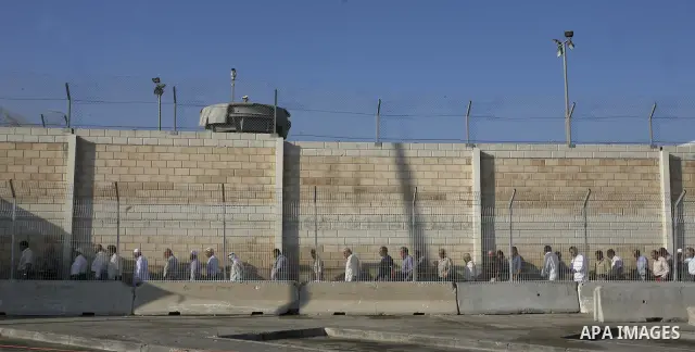 A crowd of Palestinian men wait to pass the first of several checkpoints at the Kalandia Checkpoint crossing leading from the West Bank into the Jerusalem area on 27 August 2010. Tens of thousands of people jammed the ch...