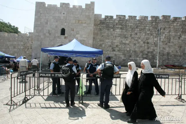 Palestinian worshippers walk past Israeli soldiers outside the Dome of the Rock, in the Al-Aqsa mosque compound in Jerusalem, during the third Friday noon prayer of the holy fasting month of Ramadan on August 27, 2010. P...