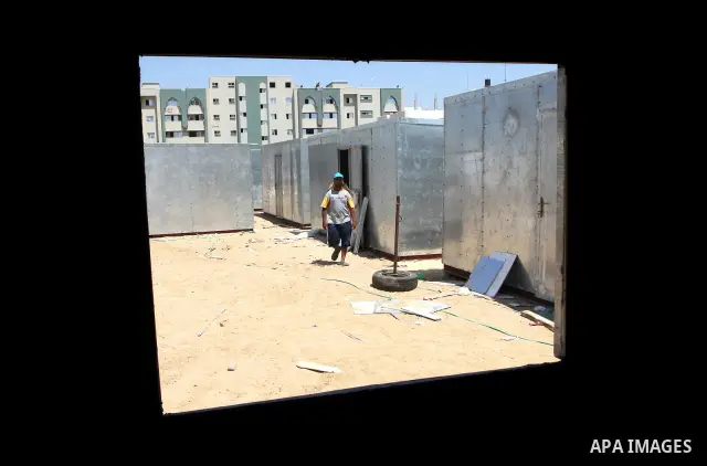 Palestinian workers from the Ministry of Transport, construct containers use as temporary shelter in the Hamas police stations instead of the destroyed stations during the Israeli war on Gaza Strip, in Gaza City on Augus...