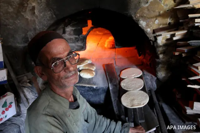 A Palestinian baker prepares loaves of bread at his traditional bakery in Gaza City on August 29,2010 . Photo by Ashraf Amra