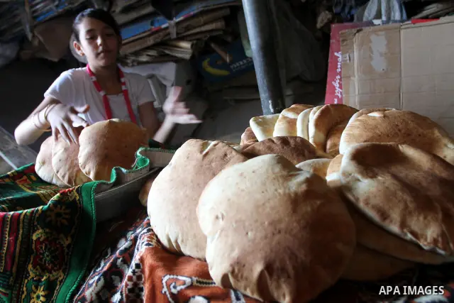 A Palestinian girl prepares Loaves of bread for the baker at his traditional bakery in Gaza City on August 29,2010 . Photo by Ashraf Amra