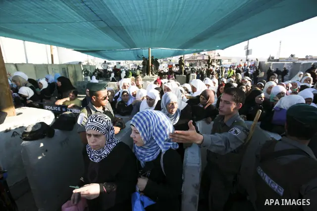 Palestinian women wait to cross at Kalandia checkpoint between Jerusalem and the West Bank city of Ramallah, to pray at al-Aqsa mosque on the last Friday of the holy month of Ramadan, Sept. 3, 2010. Muslims throughout th...