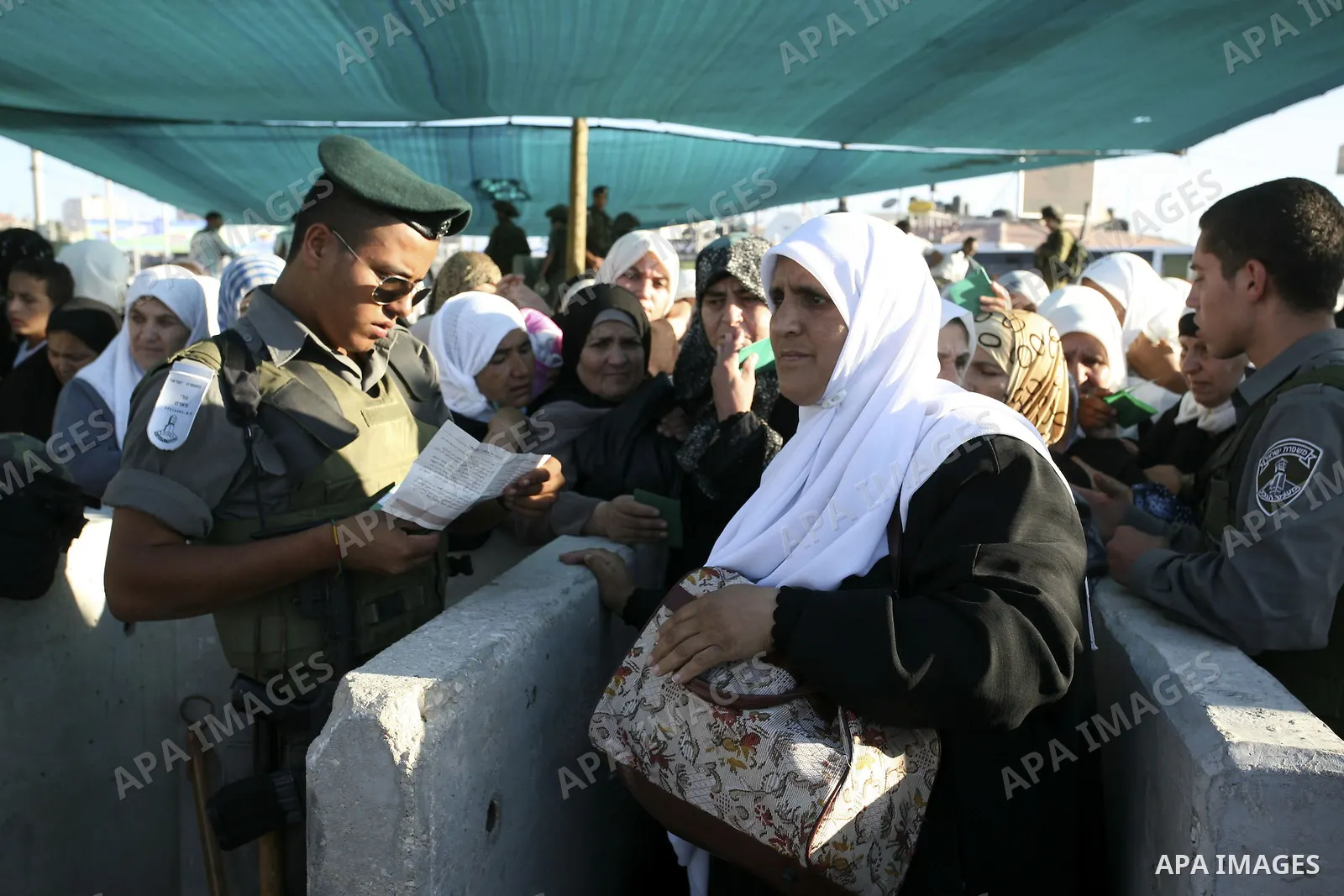 Palestinian women wait to cross at Kalandia checkpoint between Jerusalem and the West Bank city of Ramallah, to pray at al-Aqsa mosque on the last Friday of the holy month of Ramadan, Sept. 3, 2010. Muslims throughout th...