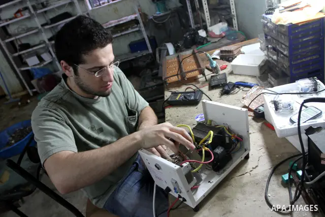 A Palestinian youth Farouk Sharaf prepares electric charger at his workshop in Gaza City on Sept 4,2010 as Gaza Strip which suffers from power outages as the lack of fuel to Gaza's power station in the city . Photo by As...