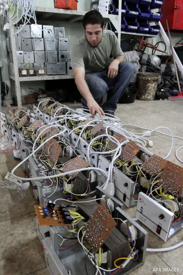 A Palestinian youth Farouk Sharaf prepares electric charger at his workshop in Gaza City on Sept 4,2010 as Gaza Strip which suffers from power outages as the lack of fuel to Gaza's power station in the city . Photo by As...