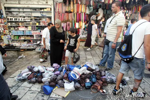 Palestinian shop in stalls at an outdoor market during preparations for Eid el-Fitr holiday, which marks the end of the holy Muslim fasting month of Ramadan , in Jerusalem's Old City on Sept. 9, 2010 . Photo by Mahfouz A...