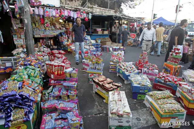 Palestinians shop in stalls at an outdoor market during preparations for Eid el-Fitr holiday, which marks the end of the holy Muslim fasting month of Ramadan, in Jerusalem's Old City on Sept. 9, 2010 . Photo by Mahfouz A...
