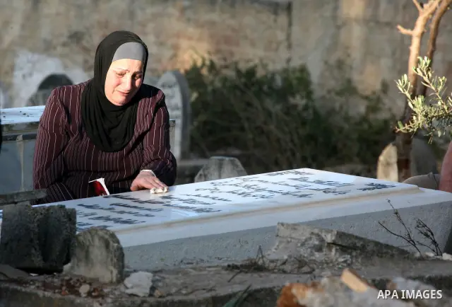 Palestinians visit the graves of their dead relatives during the early hours of the first day of the Muslim holiday Eid al-Fitr in the West Bank city of Ramallah September 10, 2010. Photo by Eyad Jadallah