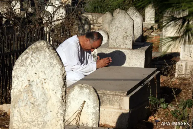 Palestinians visit the graves of their dead relatives during the early hours of the first day of the Muslim holiday Eid al-Fitr in the West Bank city of Ramallah September 10, 2010. Photo by Eyad Jadallah