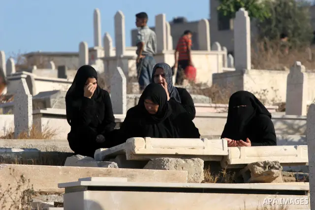 Palestinians visit their relatives' graves on the first day of Eid-al-Fitr at Shiek Redwan Cemetery in Gaza City September 10, 2010. Muslims across the world are celebrating the first day of Eid al-Fitr, the three-day ho...