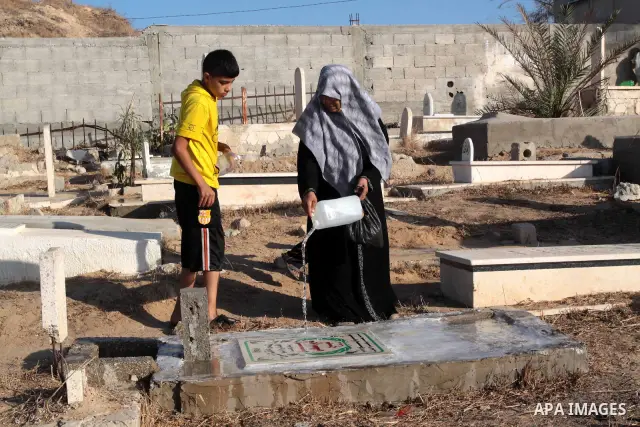 Palestinians visit their relatives' graves on the first day of Eid-al-Fitr at Shiek Redwan Cemetery in Gaza City September 10, 2010. Muslims across the world are celebrating the first day of Eid al-Fitr, the three-day ho...