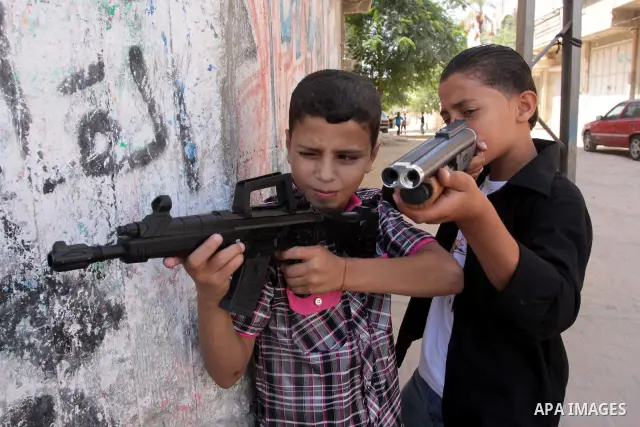Palestinian children play with toy guns on the first day of Eid al-Fitr in in Gaza City,on Sept. 10, 2010. as Muslims around the world celebrate the first day of the holiday that marks the end of the fasting month of Ram...