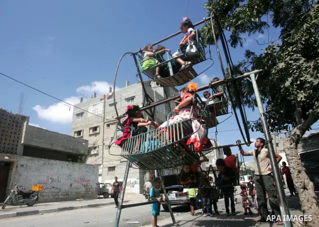 Palestinian children enjoy a ride on swings during the second day of Eid al-Fitr which marks the end of the Muslim fasting month of Ramadan, in the southern Gaza Strip town of Rafah, Sept. 11, 2010. Eid, one of the most...