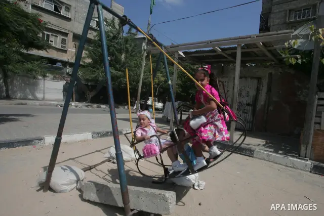Palestinian children enjoy a ride on swings during the second day of Eid al-Fitr which marks the end of the Muslim fasting month of Ramadan, in the southern Gaza Strip town of Rafah, Sept. 11, 2010. Eid, one of the most...
