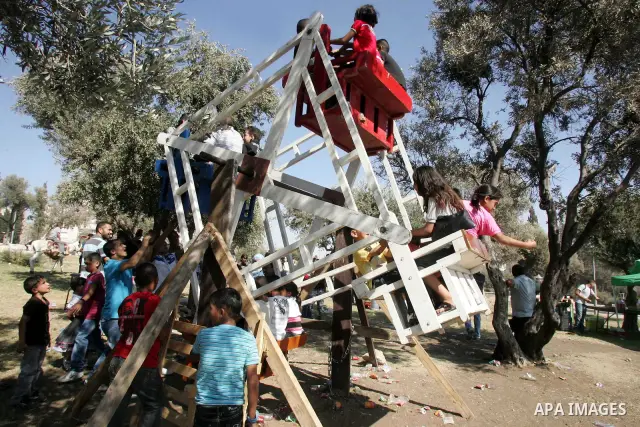 Palestinian children enjoy riding in a park on the outskirts of Israeli annexed east Jerusalem, on the second day of the Eid al-Fitr on September 11, 2010, as Muslim families continue to celebrate the end of the holy fas...