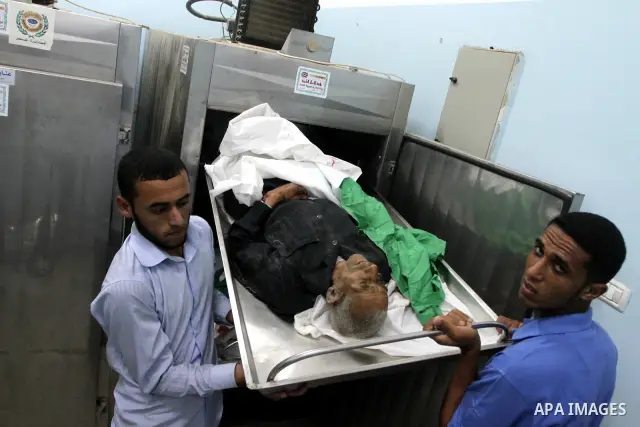 Palestinian men examine the bodies of Palestinians, killed in an Israeli shelling, in a hospital in Beit Hanoun , northern Gaza Strip, Sunday, Sept. 12, 2010. Hamas security officials say three Palestinians have been kil...