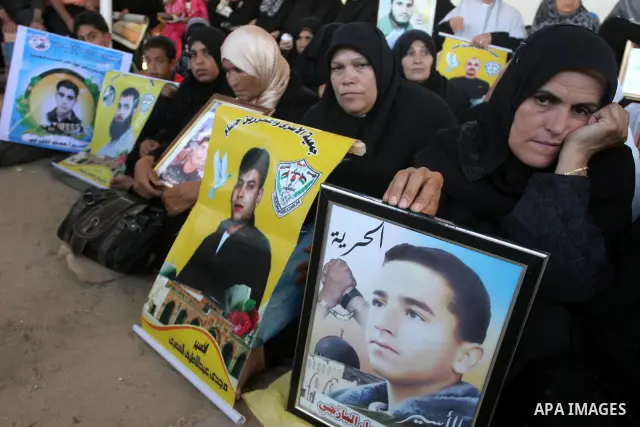 Palestinian women and children hold pictures of jailed relatives during a protest calling for the release of Palestinian prisoners from Israeli jails at the Red Cross office in Gaza City on Sept 13,2010 . Photo by Mohamm...