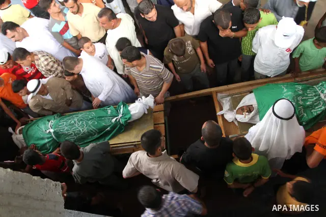 Palestinians stand beside the bodies of Palestinian 91-year-old farm caretaker Ibrahim Abdullah Abu Saeed and his teenaged grandson Hossam Khaled Abu Saeed during their funeral in nearby Jabalia in the northern Gaza Stri...