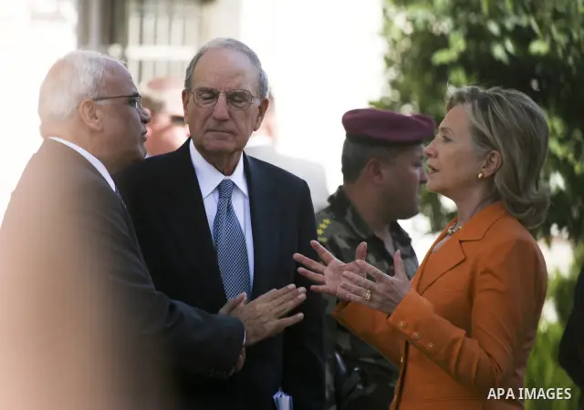 U.S. Secretary of State Hillary Rodham Clinton, talks with Palestinian senior negotiator Saeb Erekat , left, and Special Middle East Envoy former Sen. George Mitchell after their meeting with Palestinian president Mahmou...
