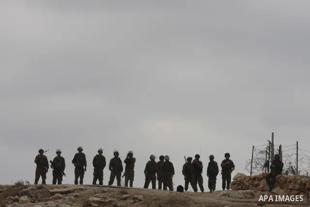 Israeli soldiers stands guard during a proteste by Palestinian and foreign activists against Israel's separation barrier in the West Bank village of Bilin near Ramallah on September 17, 2010. Photo by Eyad Jadallah