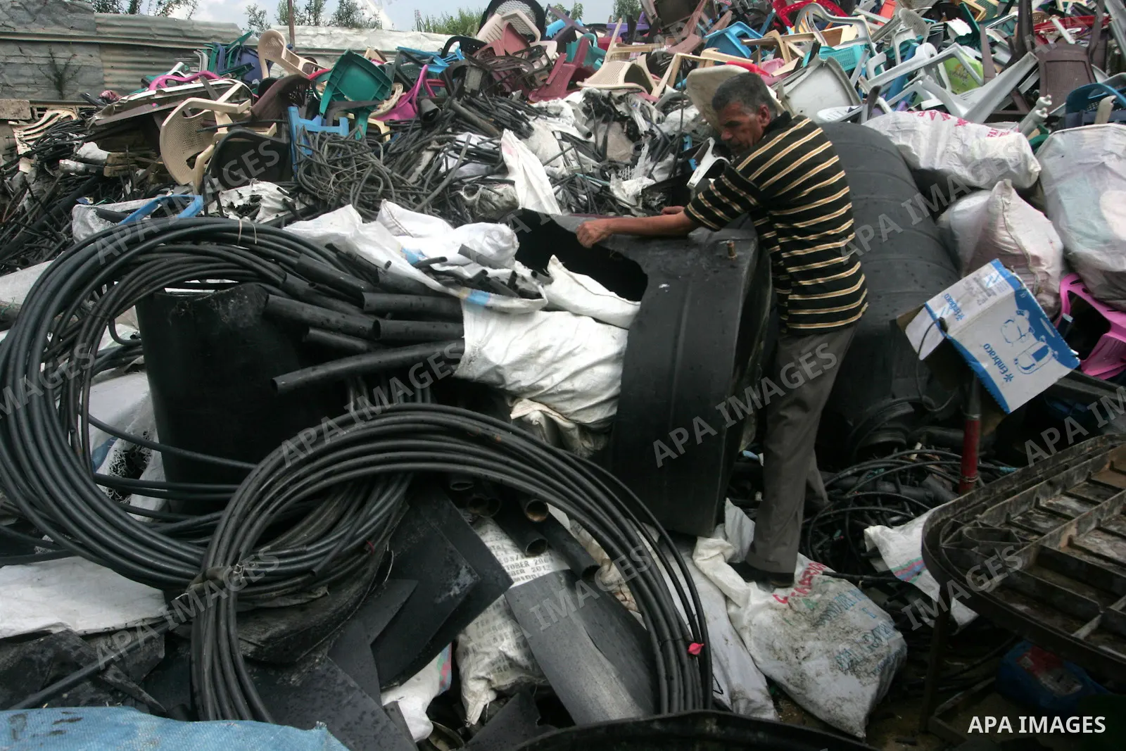 A Palestinian worker collects pieces of plastic for reusing at his shop in the southern Gaza Strip town of Khan Younis on Sept 19, 2010. Photo by Khaled Khaled