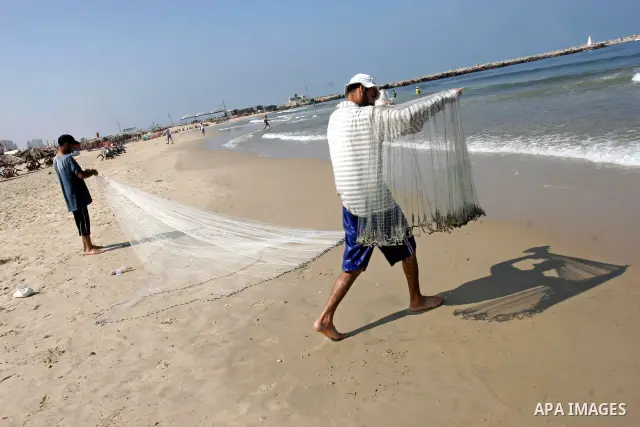 Palestinian men fishing on the beach of Gaza city on Sept. 20, 2010 . The Israeli navy opened fire on fishermen from the besieged Gaza Strip,Witnesses did not report any casualties. About 3,500 fishermen struggle to ply...
