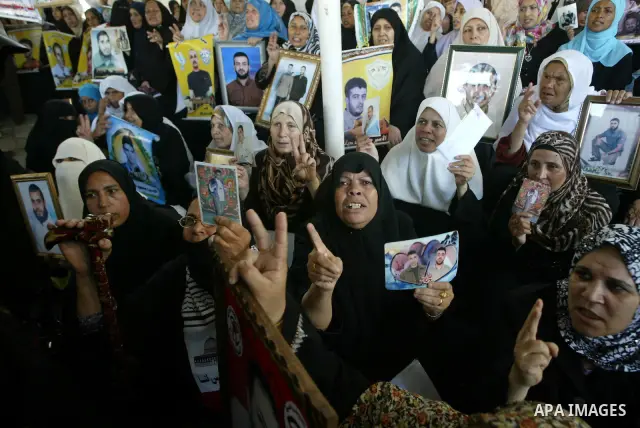 Palestinian women hold pictures of jailed relatives during a protest calling for the release of Palestinian prisoners from Israeli jails at the Red Cross office in Gaza City on Sept 20,2010 . Photo by Ashraf Amra
