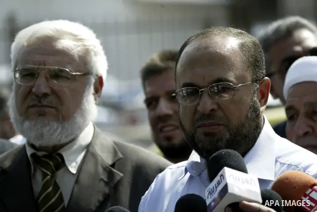 Hamas member of the Palestinian Legislative Council (PLC) Abdul Rahman Zeidan speaks to the press after he accused the Palestinian Authority of arresting him for few hours, as parliamentary speaker Aziz al-Dweik stands n...
