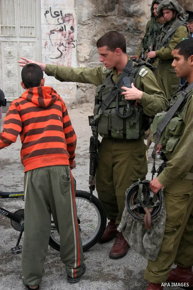 Israeli soldiers search for Palestinian students during a raid on a Palestinian school in the West Bank city of Hebron, on Sept. 22,2010. Two Palestinian students were arrested by Israeli troops during the operation at a...