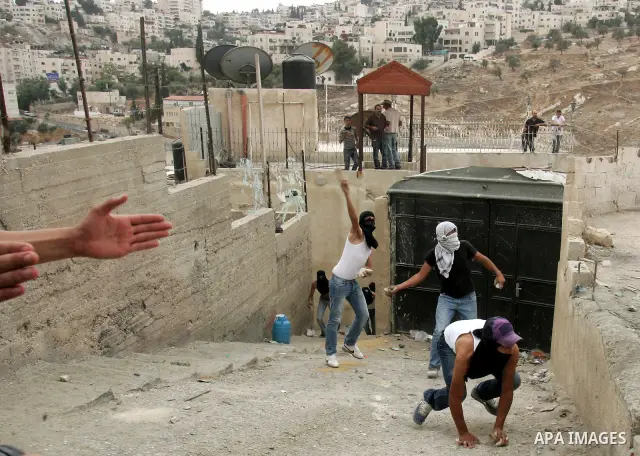 Palestinian youths hurl stones at Israeli soldiers during the clashes in the east Jerusalem neighborhood of Silwan, Wednesday, Sept. 22, 2010. Violence erupted after a 32-year-old Palestinian laborer was killed by a priv...