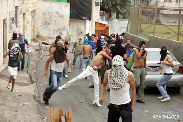 Palestinian youths hurl stones at Israeli soldiers during the clashes in the east Jerusalem neighborhood of Silwan, Wednesday, Sept. 22, 2010. Violence erupted after a 32-year-old Palestinian laborer was killed by a priv...