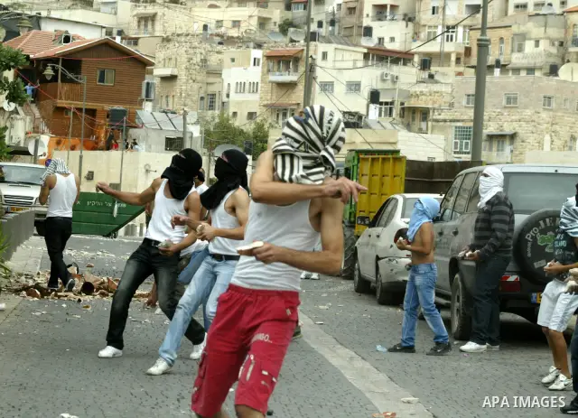 Palestinian youths hurl stones at Israeli soldiers during the clashes in the east Jerusalem neighborhood of Silwan, Wednesday, Sept. 22, 2010. Violence erupted after a 32-year-old Palestinian laborer was killed by a priv...