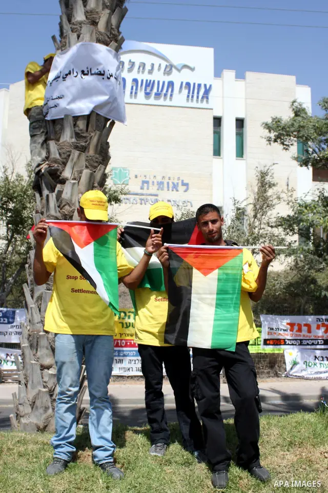 Members of the Palestinian Popular Committee for Boycotting Settlement Products protest outside an Israeli Shopping Center on the northern outskirts of the West Bank city of Ramallah, near the Adam settlement, to call fo...