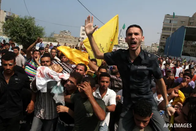 Palestinian mourners carry the body of fisherman Mohammed Baker mourn during his funeral in Gaza September 24, 2010. The Israeli navy fired on a Palestinian boat off the northern Gaza Strip on Friday, killing Baker, the...