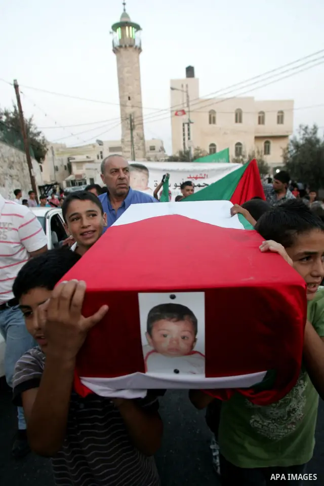 Palestinian children carry a mock coffin of 18-month-old baby Mohammed Abu Sneneh (Abu Sarah), who died at his house on September 23 from inhaling tear gas from an Israeli grenade fired during clashes with Palestinians,...