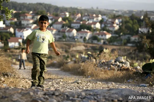 A Palestinian boy walks in front of an Israeli jewish settlement near the village of Ni'lin in the West bank city of Ramallah on Sept. 28, 2010. Photo by Eyad Jadallah