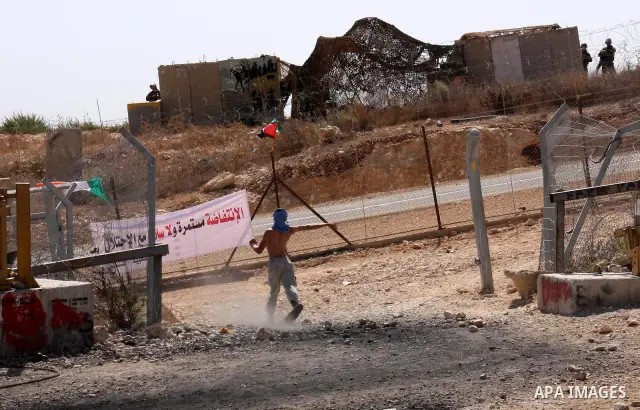 A Palestinian youth hurls stones at Israeli soldiers during a protest against Israel's separation barrier in the West Bank village of Bilin near Ramallah, Friday, Oct. 1, 2010. U.S. Middle East envoy George Mitchell was...