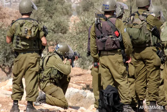 Israeli soldiers attack the Palestinians and foreign activists during a protest against Israel's separation barrier in the West Bank village of Bilin near Ramallah, Friday, Oct. 1, 2010. U.S. Middle East envoy George Mit...