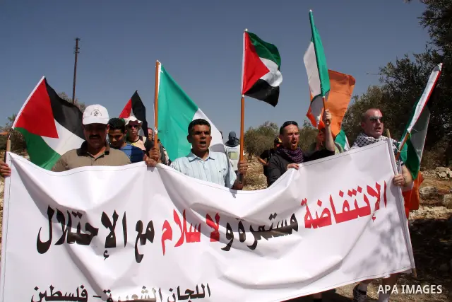Palestinians and foreign activists take part in a protest against Israel's separation barrier in the West Bank village of Bilin near Ramallah, Friday, Oct. 1, 2010. U.S. Middle East envoy George Mitchell was shuttling be...