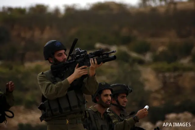Israeli soldiers stand guard during a demonstration by Palestinian, Israeli and foreign activists against Israel's controversial separation barrier in the West Bank village of Beit Omar, near Hebron, on Oct. 2,2010. Isra...