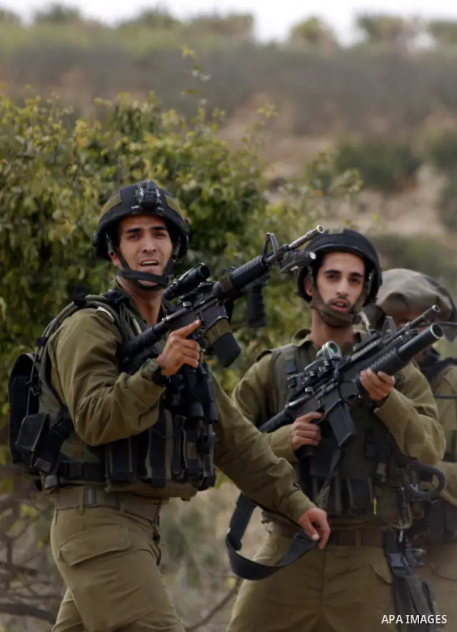 Israeli soldiers stand guard during a demonstration by Palestinian, Israeli and foreign activists against Israel's controversial separation barrier in the West Bank village of Beit Omar, near Hebron, on Oct. 2,2010. Isra...