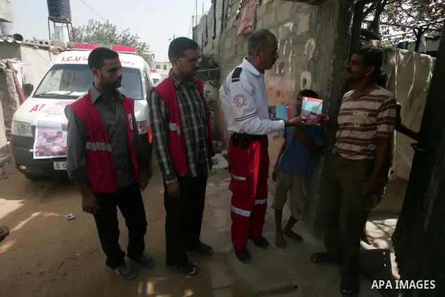 Palestinian members of the Red Crescent distribute leaflets to people in the remote places in the southern Gaza Strip city of Rafah on Oct. 3,2010 to mark the International Day for the ambulance and emergency.. Photo by...