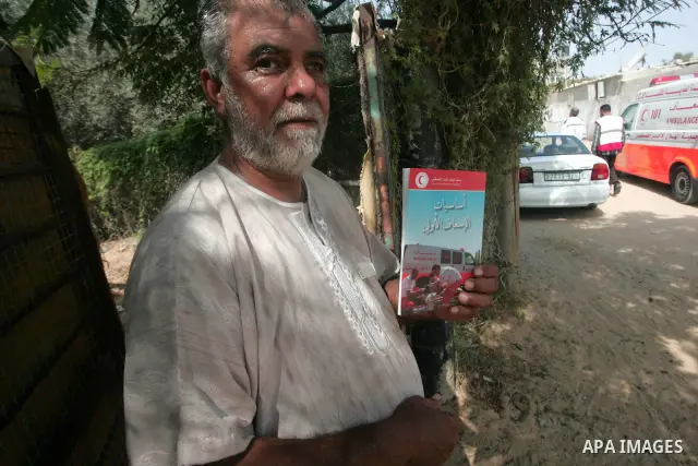 Palestinian members of the Red Crescent distribute leaflets to people in the remote places in the southern Gaza Strip city of Rafah on Oct. 3,2010 to mark the International Day for the ambulance and emergency.. Photo by...
