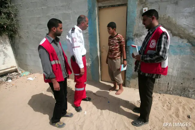 Palestinian members of the Red Crescent distribute leaflets to people in the remote places in the southern Gaza Strip city of Rafah on Oct. 3,2010 to mark the International Day for the ambulance and emergency.. Photo by...