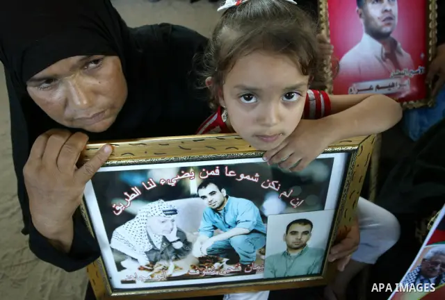 Palestinian women and children hold pictures of jailed relatives during a protest calling for the release of Palestinian prisoners from Israeli jails at the Red Cross office in Gaza City on October 4,2010 . Photo by Ashr...