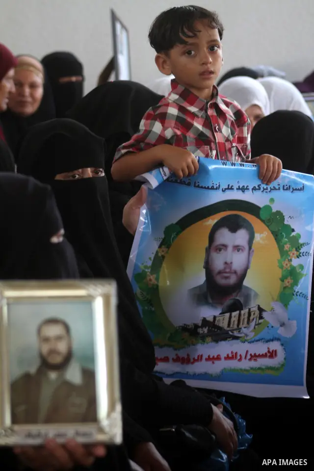 Palestinian women and children hold pictures of jailed relatives during a protest calling for the release of Palestinian prisoners from Israeli jails at the Red Cross office in Gaza City on October 4,2010 . Photo by Ashr...