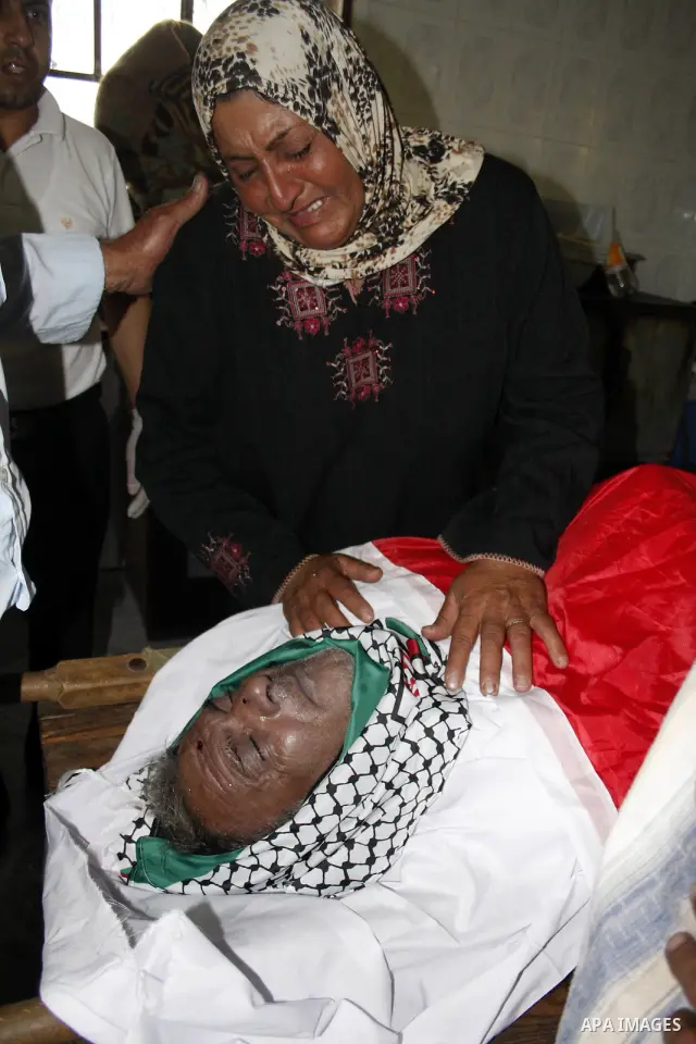 Palestinians mourn at the body of Palestinian Shehda Karaja, 55, during his funeral near the Israeli occupied West Bank city of Hebron on October 4,2010. Karaja was died after a heart attack after being fear and inhaling...